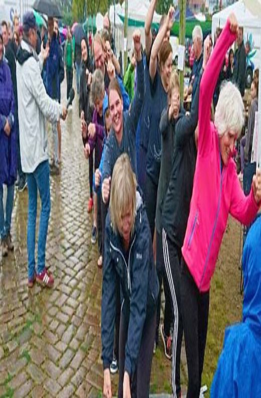 Eine Gruppe Menschen übt an Land die Bewegungsabläufe, die nötig sind, um ein Drachenboot vorwärts zu bekommen.