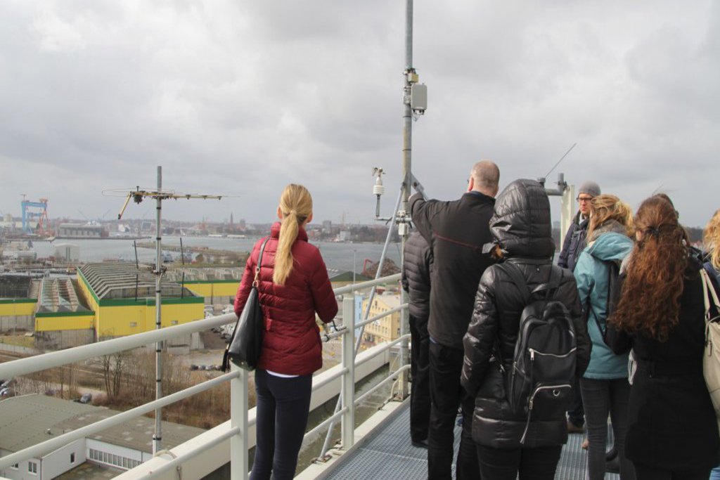 Eine Gruppe steht auf dem Dach eines Gebäudes und erschliesst die angrenzende Umgebung.