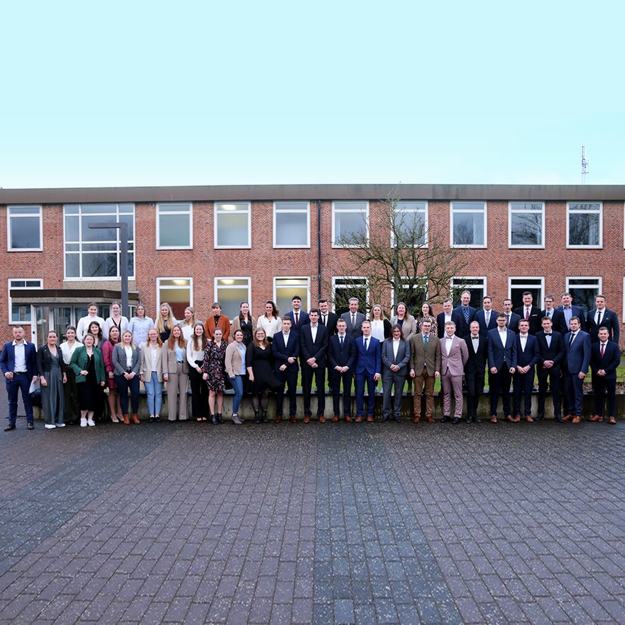 die Absolventinnen und Absolventen des Wintersemesters mit Dekan Prof. Martin Braatz stehen vor dem Gebäude auf dem Campus in Osterrönfeld