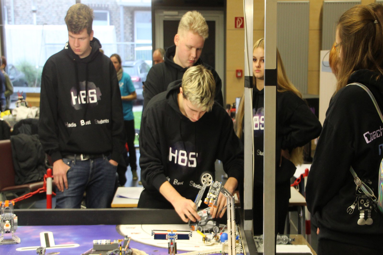 Eine Gruppe Studierende steht um einen Versuchsaufbau.