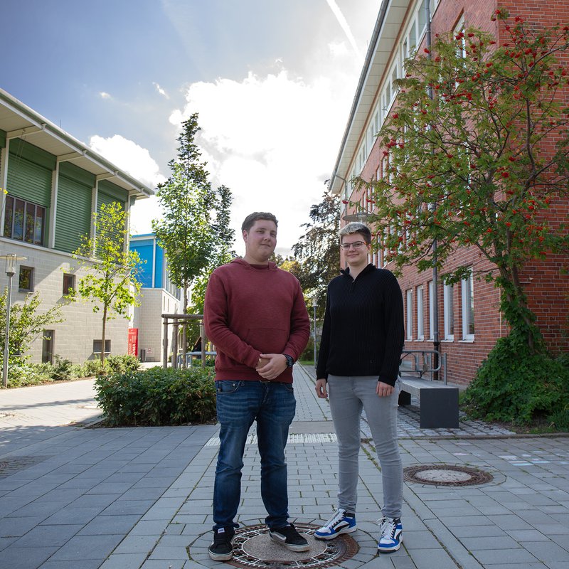 zwei Studierende stehen auf dem Campus der FH Kiel in Dietrichsdorf