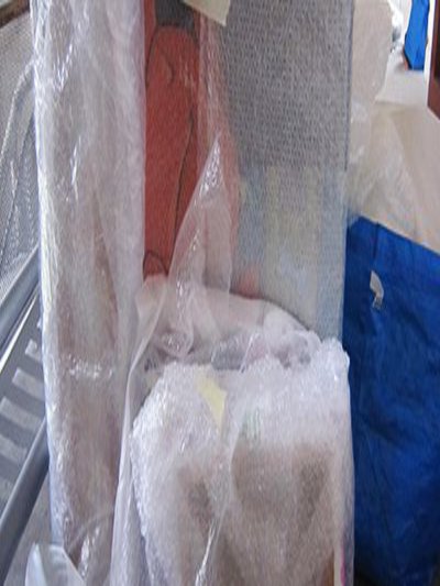 Ein Stapel in Schutzfolie verpackter Bilder.