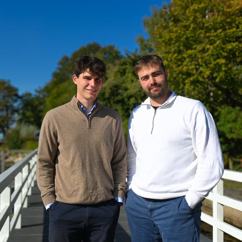 Zwei junge Männer stehen auf einer Brücke.