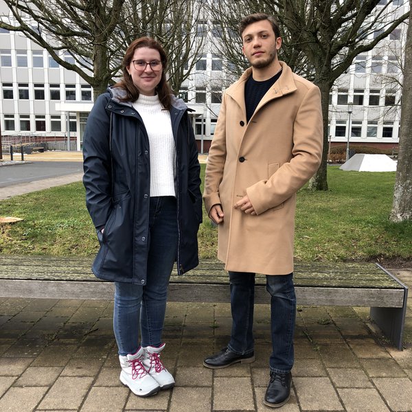 Eine junge Frau, Adriana Balasa, und ein junger Mann, Alejandro Castellanos, stehen auf dem Campus der FH Kiel.