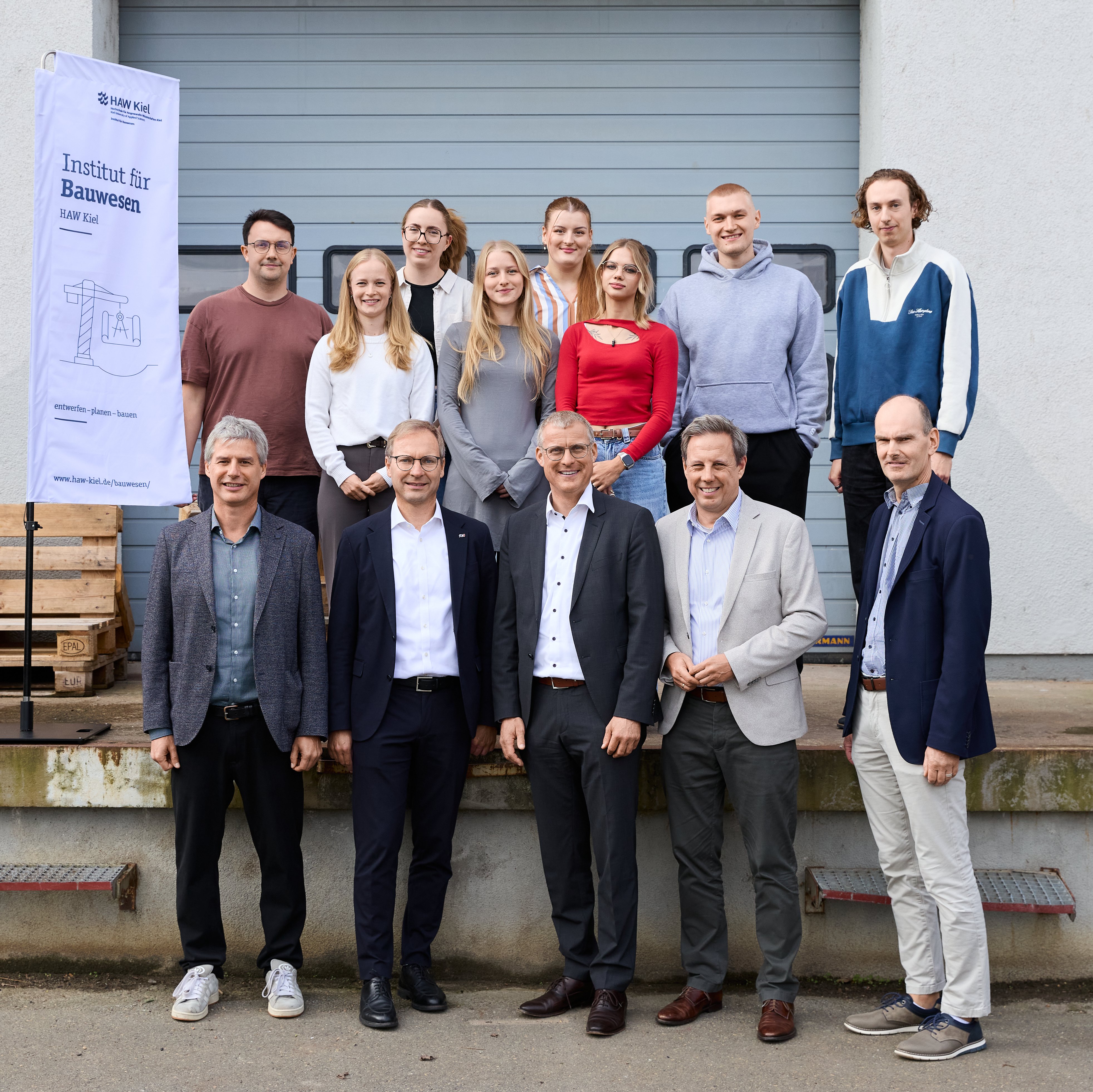Eine Gruppe Menschen steht vor einem gebäude