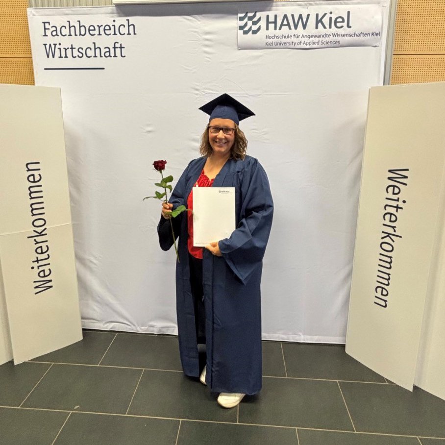 EIne Frau mit einer Auszeichnung und einer Blume.