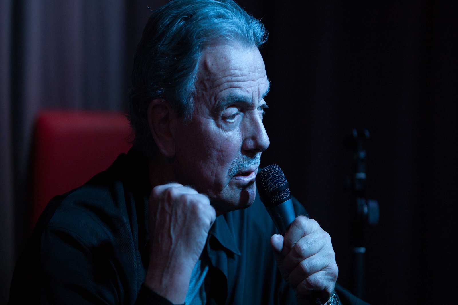 Ein Mann hält ein Mikrofon an sein Gesicht und ballt die Faust.