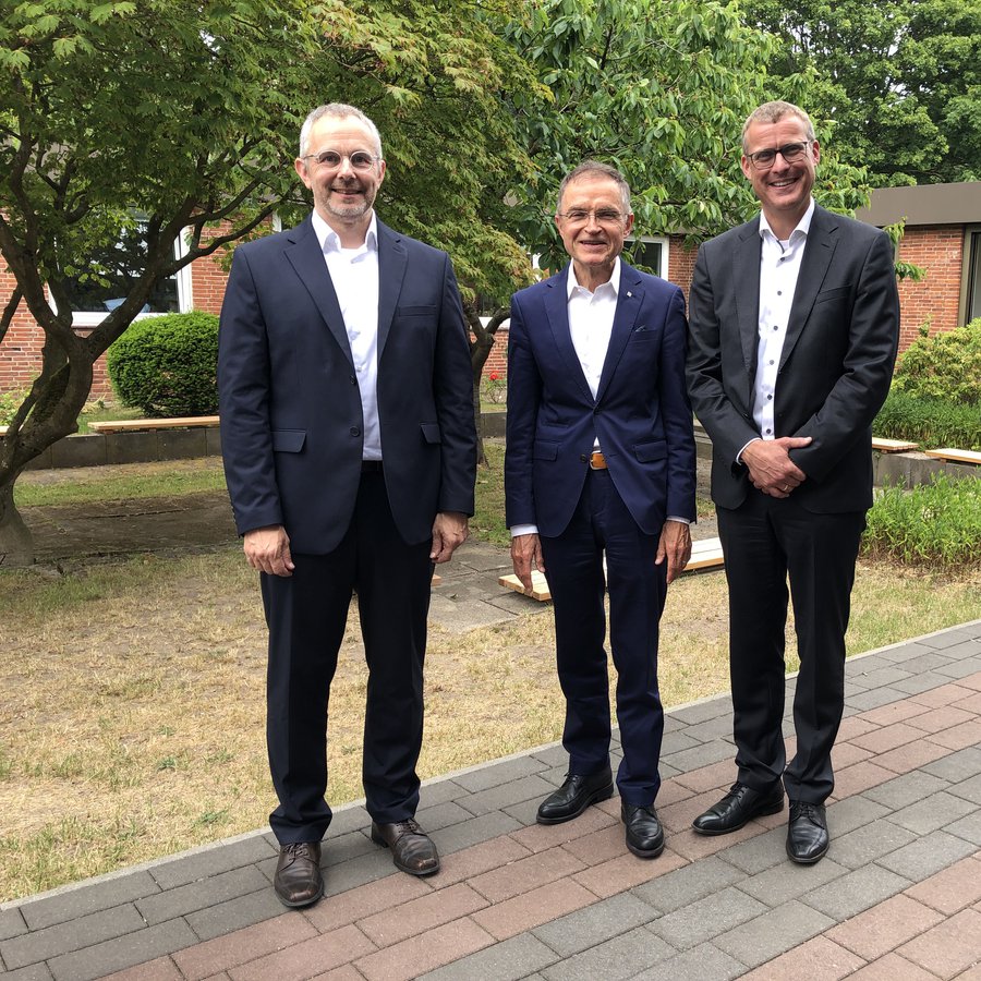 der Ehrensenator Prof. Dr. Hans Klaus (Mitte) steht mit Laudator Prof. Dr. Marco Hardiman (links) und FH-Präsident Prof. Dr. Björn Christensen im Innenhof des Gebäudes des Fachbereichs Agrarwirtschaft in Osterrönfeld. Foto: Frauke Schäfer.