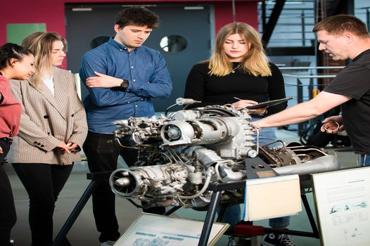 Maschinenwesen Maschinenwesen - Studierende und Profesor mit einem Motor