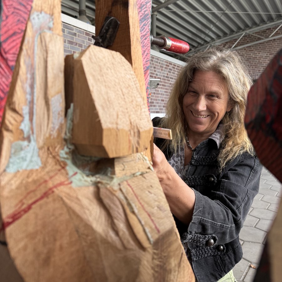 Rosa Treß arbeitet an einer roten Holzskulptur