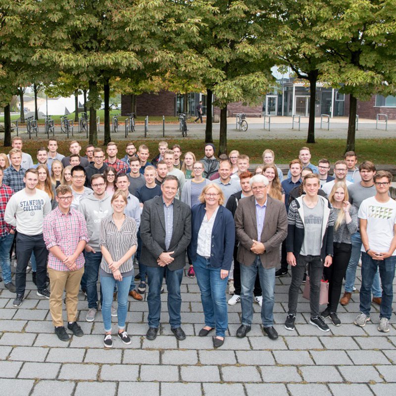 Eine große Gruppe Studierender und die Verantwortlichen für das IBS stehen auf dem Sokratesplatz 