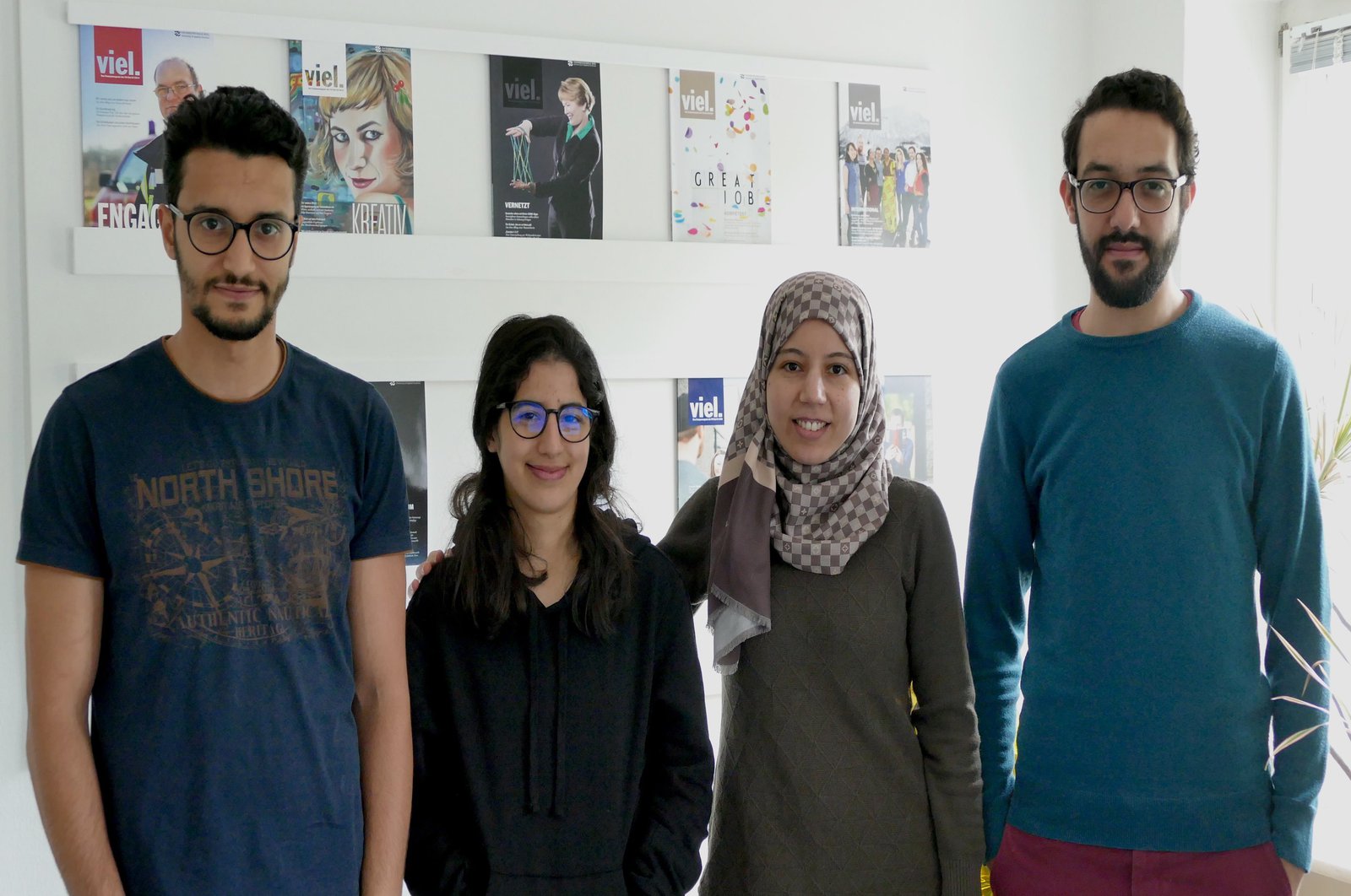 Vier Personen posieren im Konferenzraum der Stabsstelle Strategische Kommunikation.