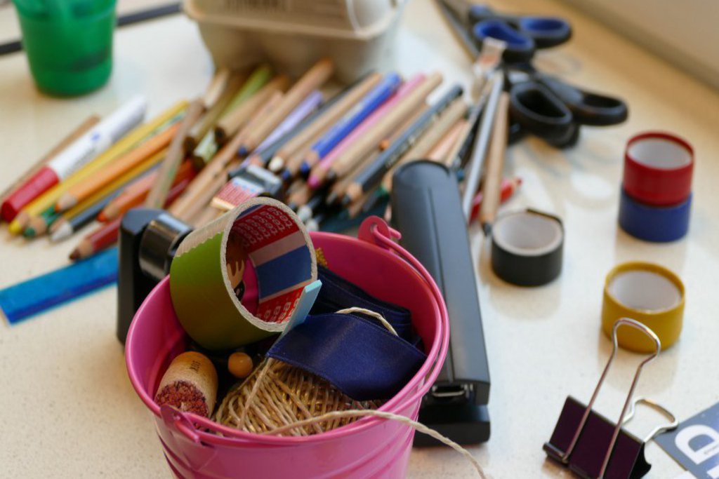 Auf einem Tisch liegen diverse Schreib- und Bastelutensilien.