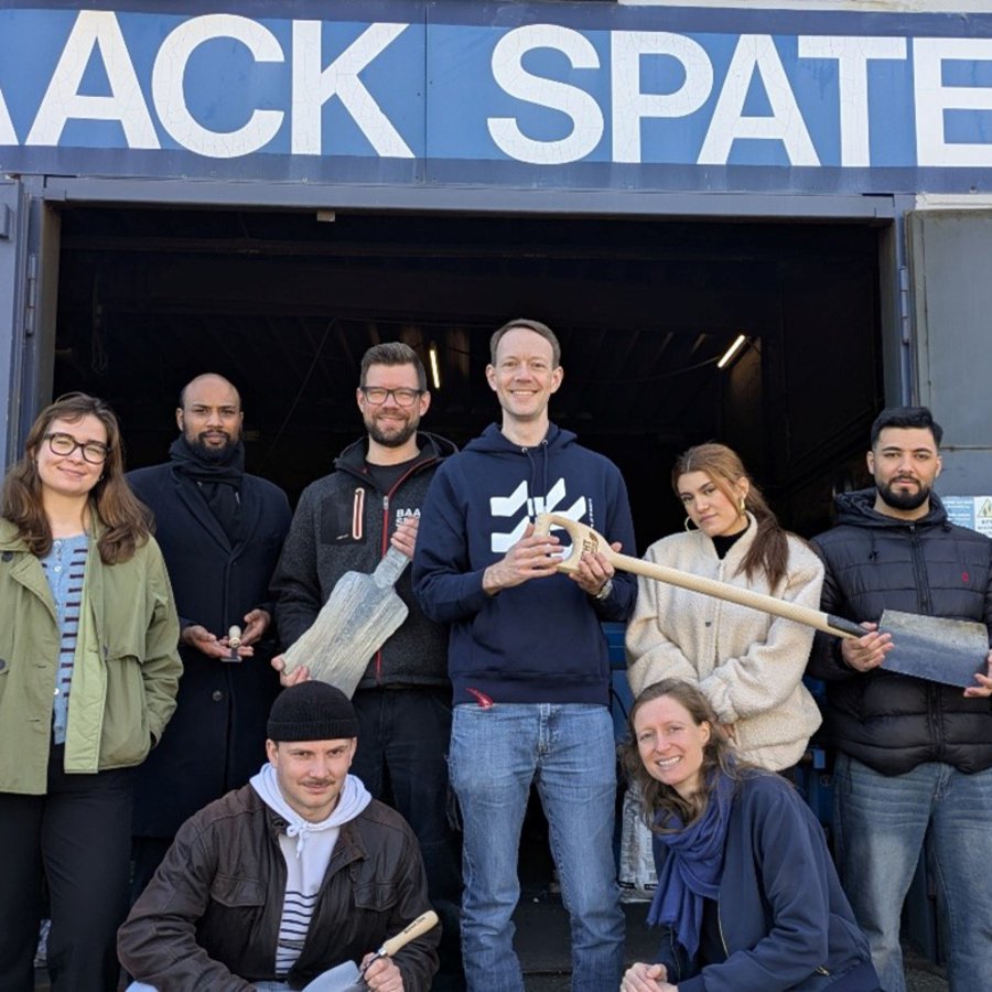 eine Gruppe von Personen steht vor dem Eingang der Firma Baack Spaten