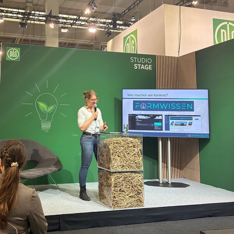 eine Frau steht auf einer Bühne und hält ein Mikrofon in der Hand  