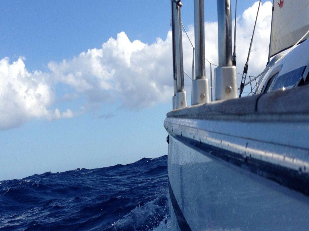 Die vordere linke Flanke eines Segelboots, das auf dem Meer fährt.