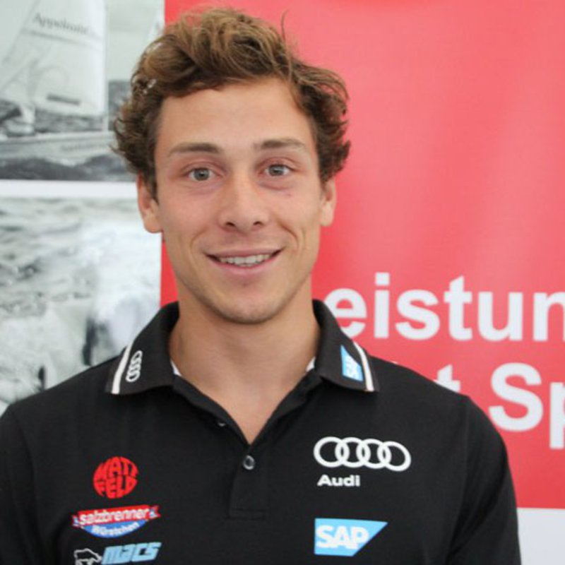 Segler Thomas Plößel vor einem Banner in der Fachhochschule Kiel