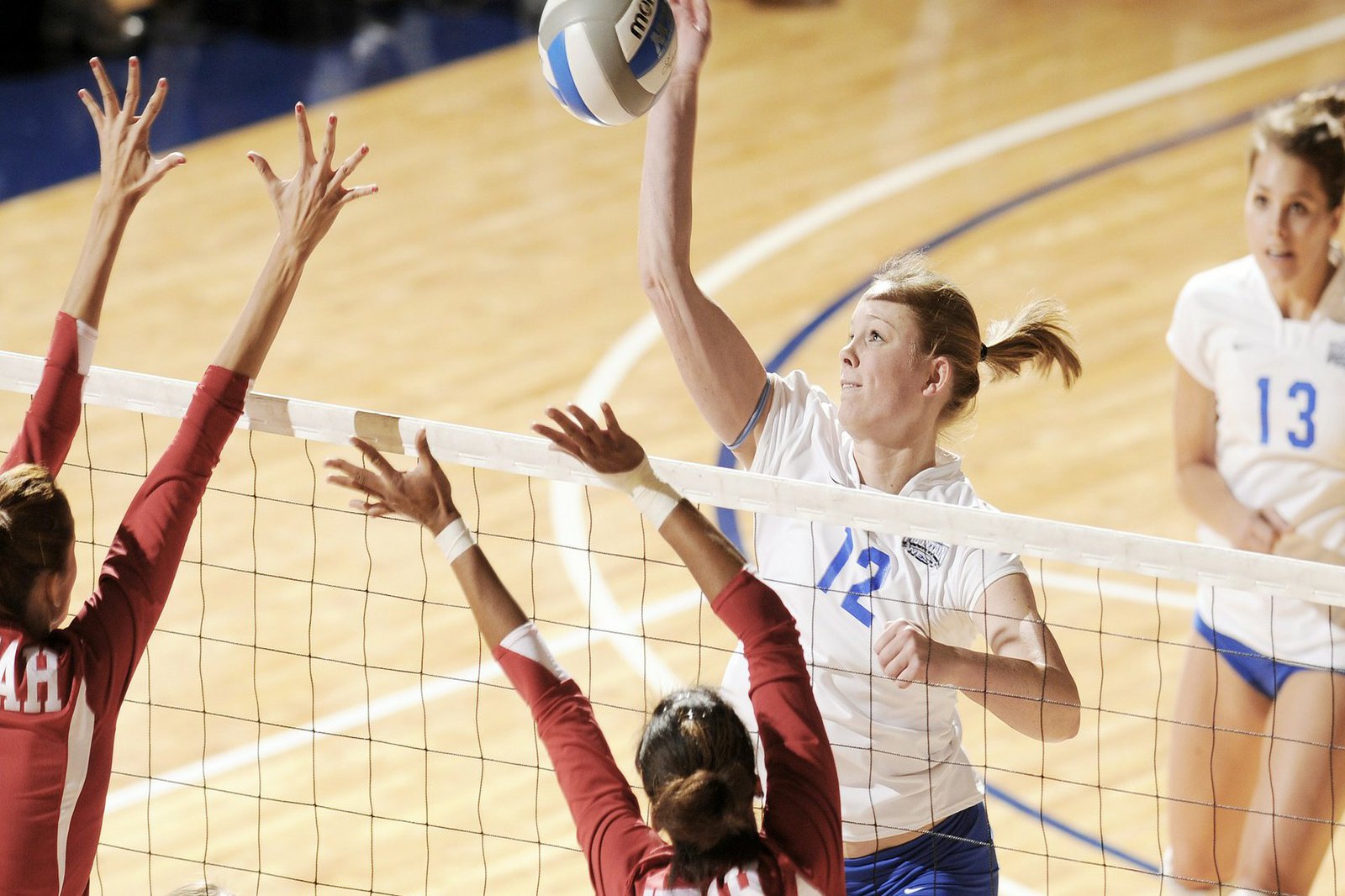 Eine Gruppe Frauen spielt Volleyball in einer Halle.
