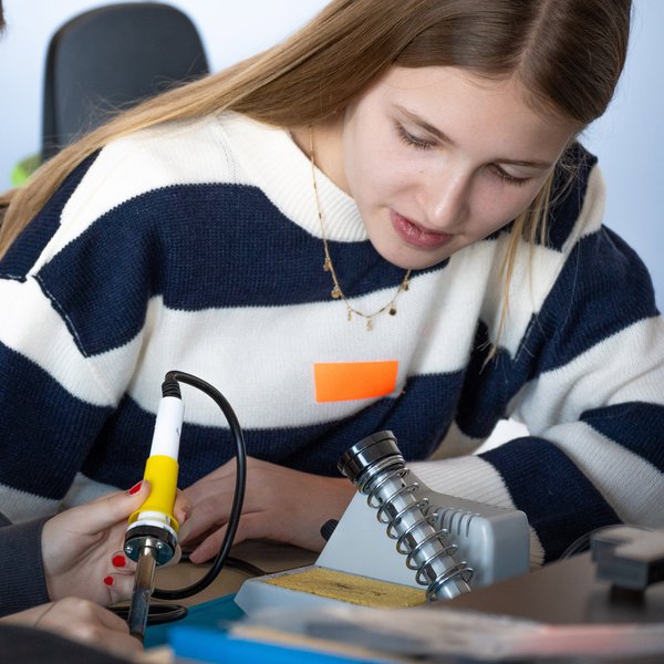 Zwei Mädchen arbeiten mit einem Lötkolben