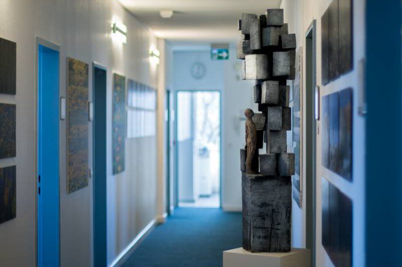 Der Flur des Präsidiums mit einer Skulptur, in der eine Figur mehrere Klötze bestaunt.