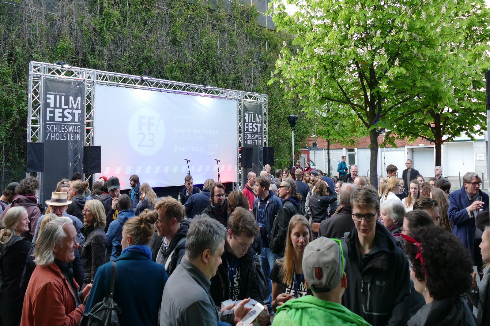 Eine Menschenmenge befindet sich vor einer Bühne.