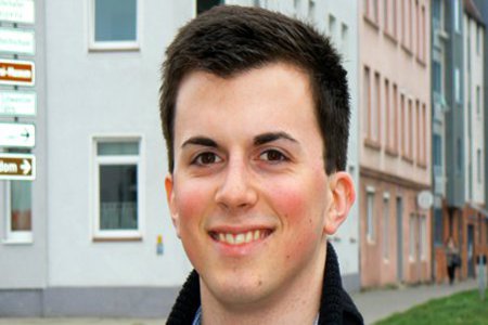 Ein Mann lächelt freundlich in die Kamera.