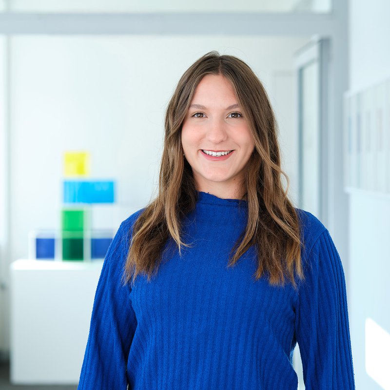 eine junge Frau in blauem Pullover auf einem Flur der HAW Kiel