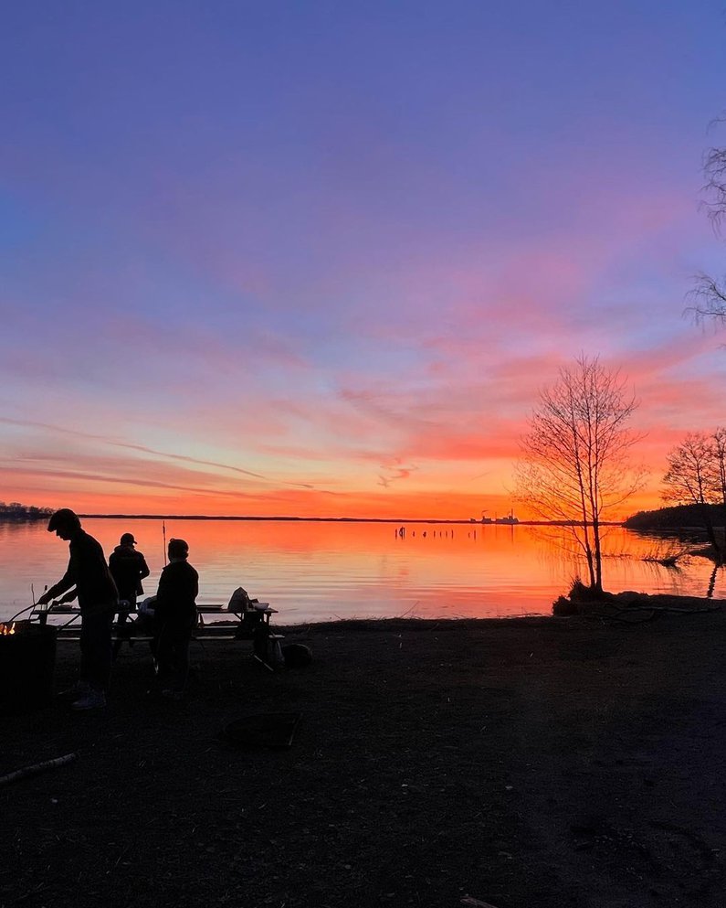 Camping und Barbeque am Ufer eines Sees bei Sonnenuntergang
