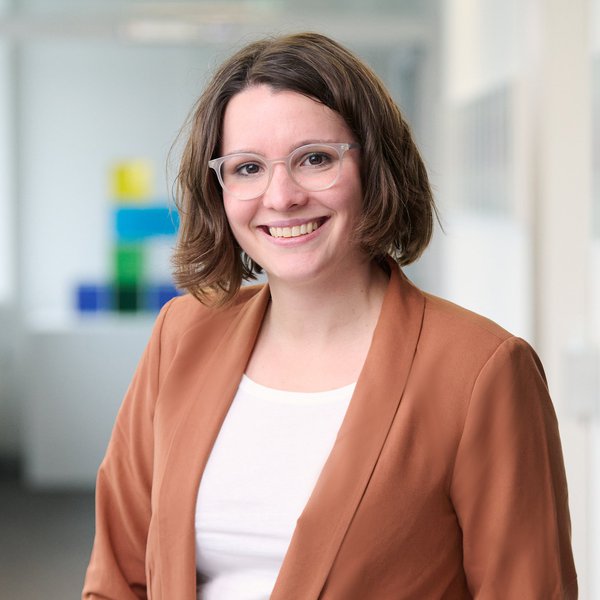 Auf dem Bild ist Dr. Susanne Czech zu sehen. Sie trägt einen ockerfarbenen Blazer und eine graue Brille.