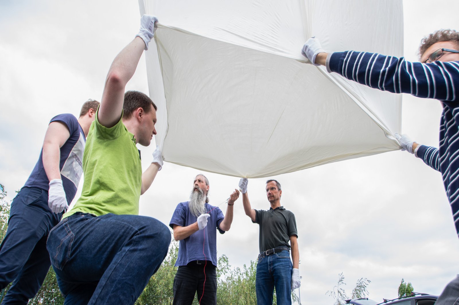 Fünf Männer bereiten einen Ballon vor, damit dieser abheben kann.