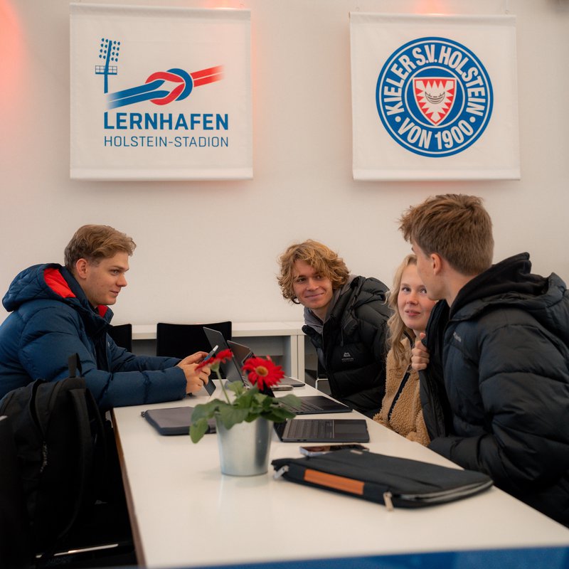 vier Studierende an einem Tisch im Lernhafen von Holstein Kiel