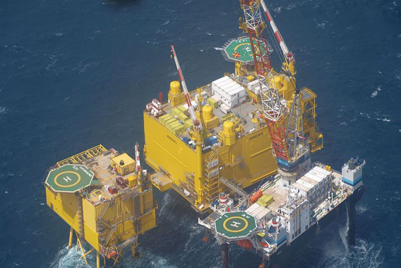 Mitten im Meer befindet sich eine Bohrinsel.