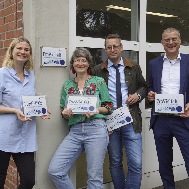 (v.l.n.r.) Alexa Magsaam, Dr. Anja Franke-Schwenk, Prof. Dr. Tobias Hochscherf und  Prof. Dr. Björn Christensen halten das Schild: ProVielfalt! Kein Platz für Diskriminierung. Foto: Leandra Freese.