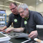 Zwei Männer an eineer Druckerpresse.