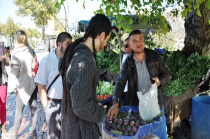 Zwei Männer kaufen etwas Obst bei einem Straßehändler.