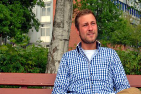 Sascha Blunk Sascha Blunk vor der Fachhochschule Kiel, auf einer Bank sitzend