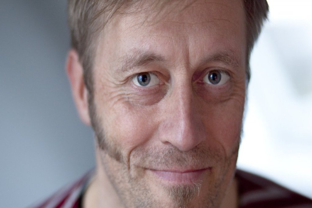 Die Nahaufnahme von Gesicht eines Mannes. Der Mann hat große spitz nach vorn verlaufende Koteletten.