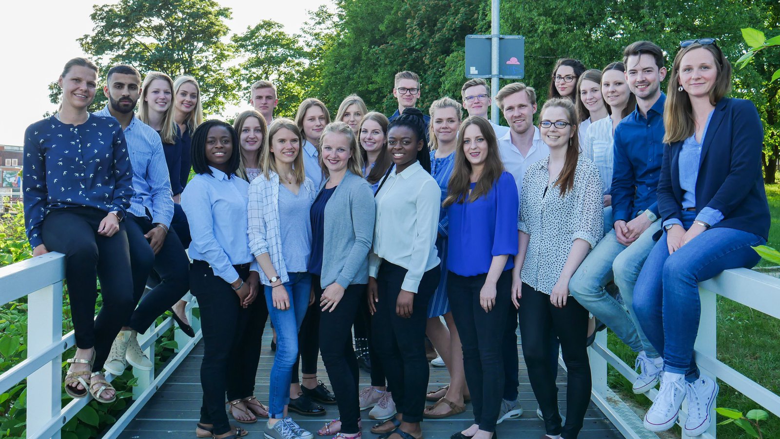 Eine Gruppe studierender posiert auf einem Steg an der Schwentinemündung.