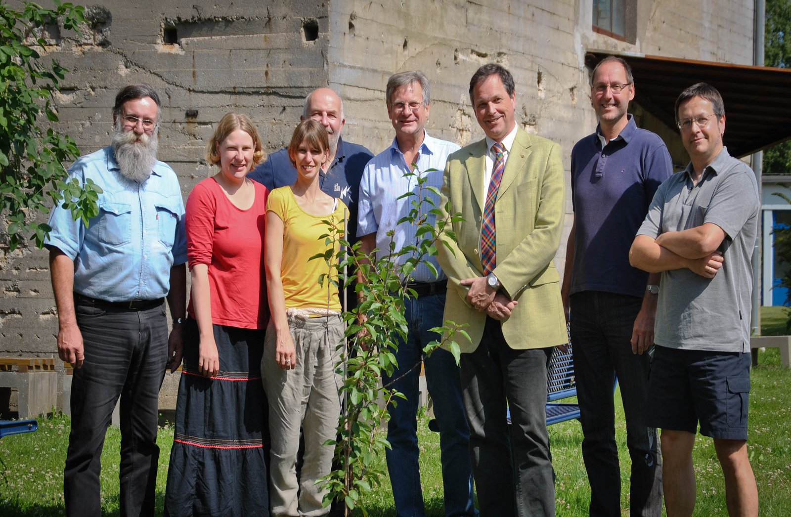 Das Team steht bei sonnigem Wetter neben dem Bunker-D und posiert für die Kamera.