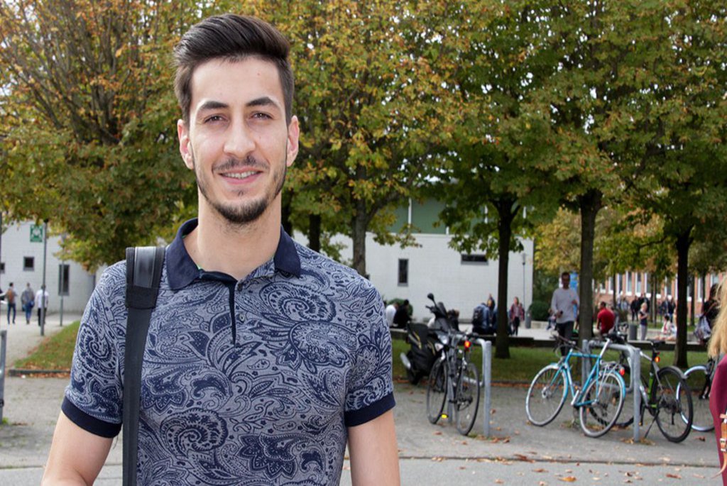 Ein mann grinst im Frein in die Kamera.