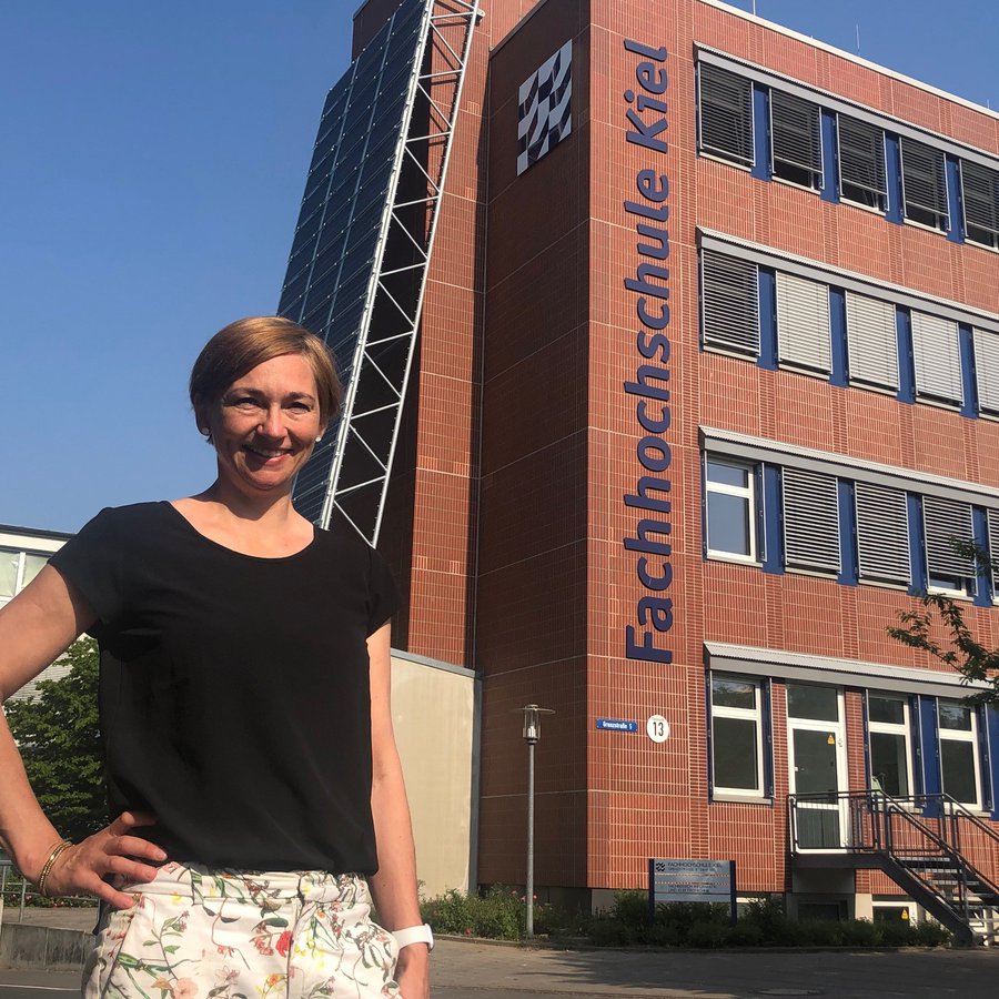 Foto: Meise Eine Frau steht vor einem Gebäude der Fachhochschule Kiel.