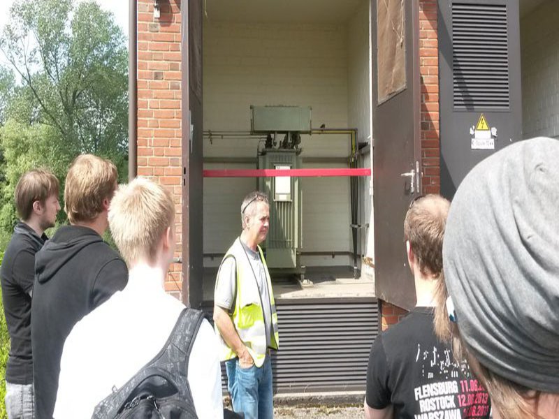 Einer Gruppe Studierender wird ein Hochspannungsraum gezeigt.