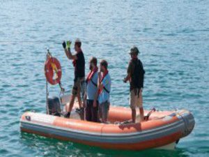 Vier Männer stehen auf einem Schlauchboot.