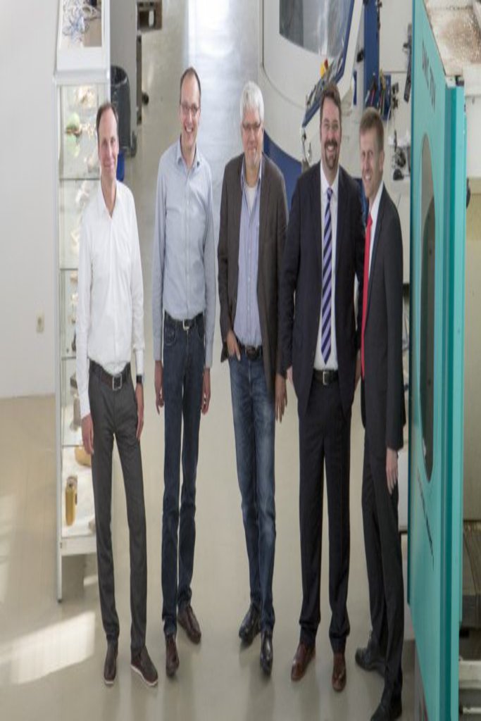 Fünf Männer stehen in einem Maschinenraum der FH Kiel und schauen freundlich nach oben  in die Kamera.