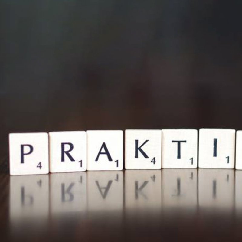 Spielsteine formen das Wort "PRAKTIKUM".