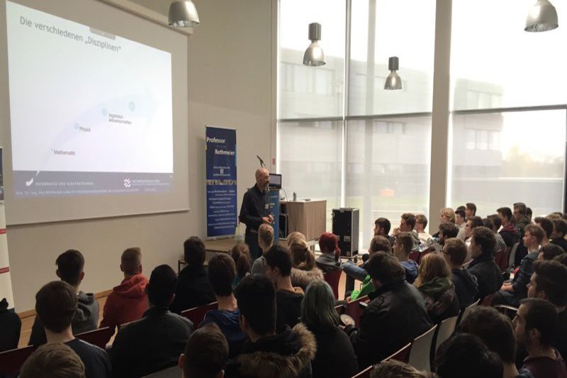 Ein Prall gefüllter Hörsaal, in dem die Schüler dem Professor gespannt zuhören.