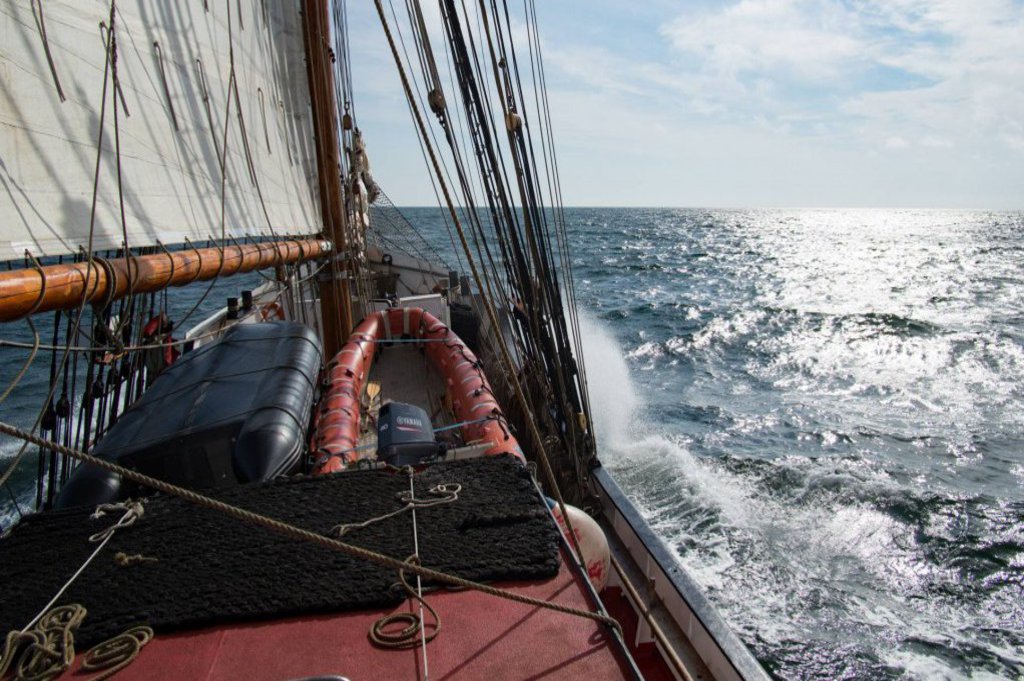 Die Front eines durch die Wellen preschenden Segelschiffes.