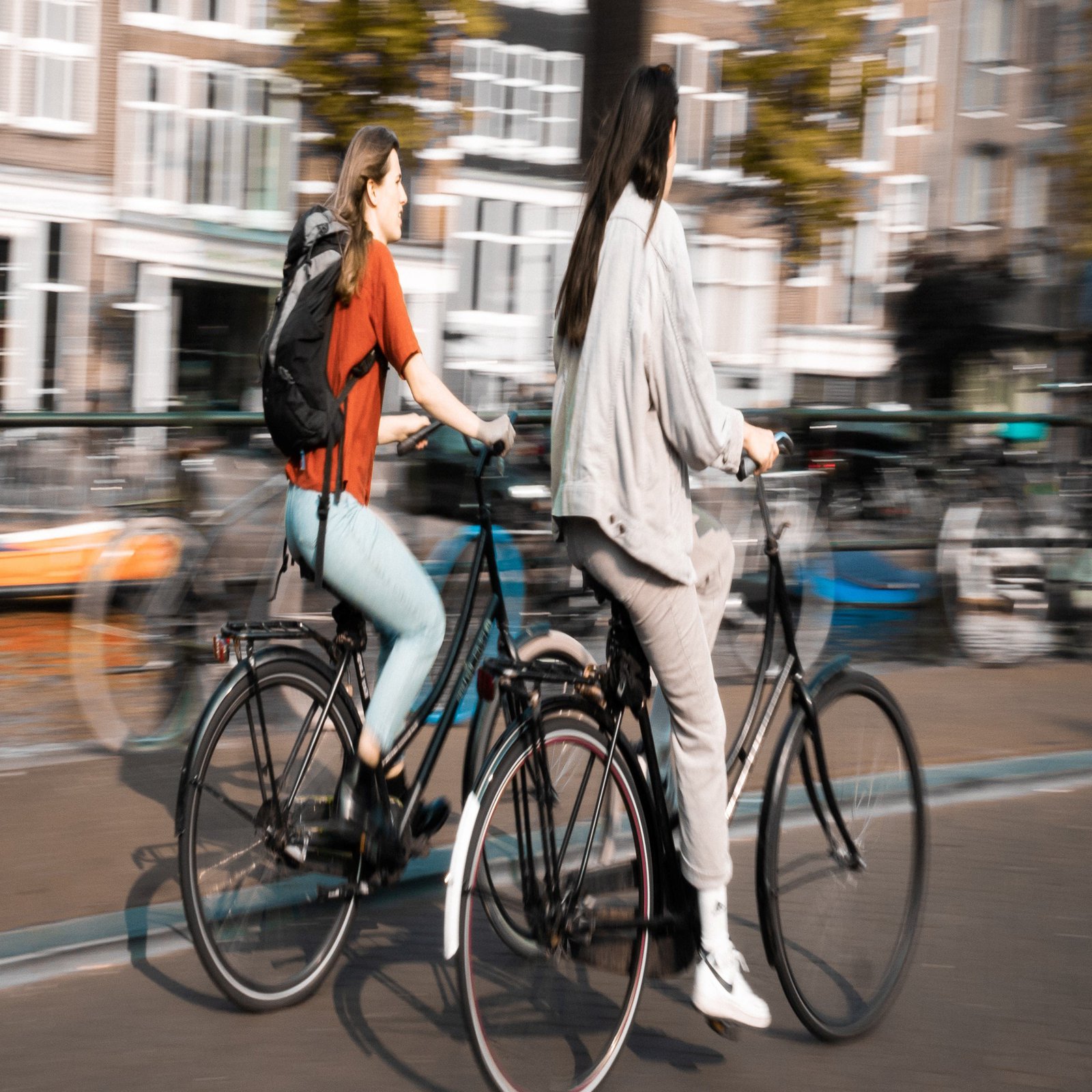 Zwei junge Frauen fahren mit Rädern durch die Stadt