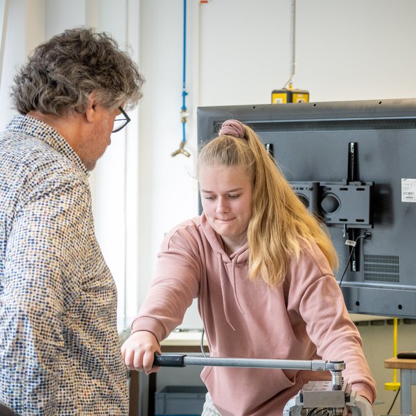 Auszubildene zieht Schraube an 