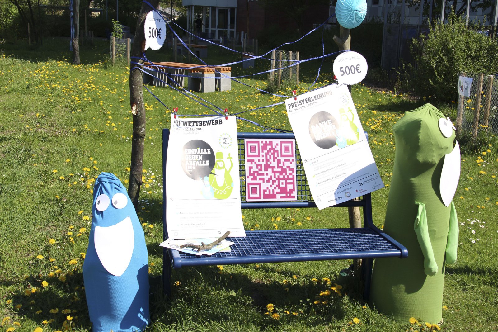 Eine blaue Bank, bestückt mit Infomaterialien und Pappfiguren.